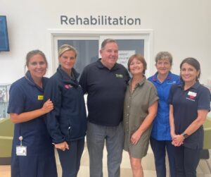 Group of healthcare professionals and a visitor in a rehabilitation centre.